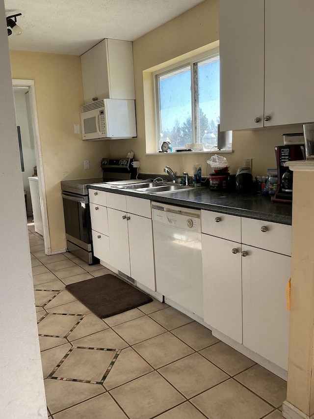 2007 M30, Gladwin, MI 48624 - kitchen with white appliances, a sink, dark countertops, white cabinetry, and light tile patterned flooring