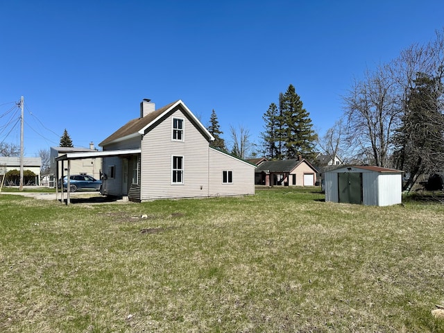 1117 Mackinaw Ave, Cheboygan, MI 49721 - exterior space with a storage shed, a lawn, a chimney, and an outdoor structure
