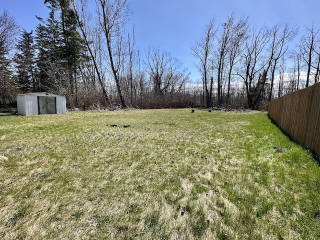 1117 Mackinaw Ave, Cheboygan, MI 49721 - view of yard featuring fence, an outbuilding, and a shed
