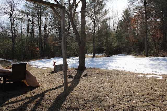 yard covered in snow with a forest view