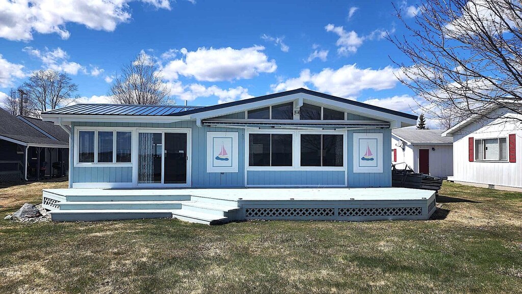 13368 W Shore Dr, Houghton Lake, MI 48629 - back of house featuring a wooden deck, metal roof, and a lawn