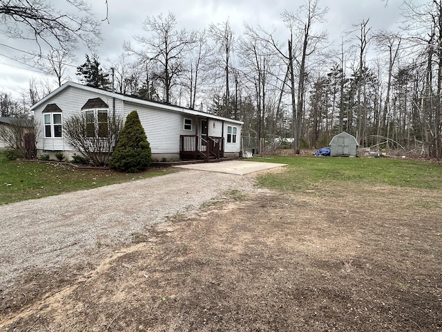 5128 Krys Rd, Gaylord, MI 49735 - exterior space featuring a storage unit, an outbuilding, a front yard, and dirt driveway