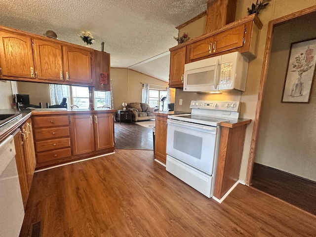 5128 Krys Rd, Gaylord, MI 49735 - kitchen featuring brown cabinetry, dark wood-style flooring, a textured ceiling, vaulted ceiling, and white appliances