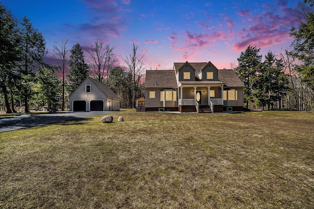 new england style home featuring a front lawn, an outbuilding, covered porch, and a garage