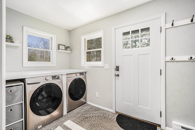 laundry area with washing machine and dryer, plenty of natural light, baseboards, and laundry area