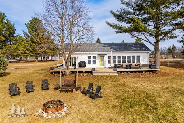 4565 Grant Dr, Lewiston, MI 49756 - back of house with fence, a wooden deck, an outdoor fire pit, and a yard