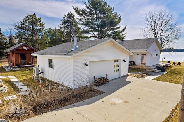 4565 Grant Dr, Lewiston, MI 49756 - view of side of property featuring concrete driveway, a shingled roof, and a garage