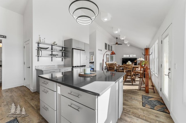 4565 Grant Dr, Lewiston, MI 49756 - kitchen with open shelves, freestanding refrigerator, light wood-type flooring, and a center island