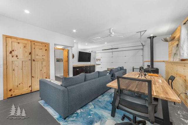 4565 Grant Dr, Lewiston, MI 49756 - living area featuring a garage, recessed lighting, a wood stove, and finished concrete flooring