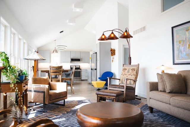 4565 Grant Dr, Lewiston, MI 49756 - living room with light wood-type flooring, visible vents, and high vaulted ceiling