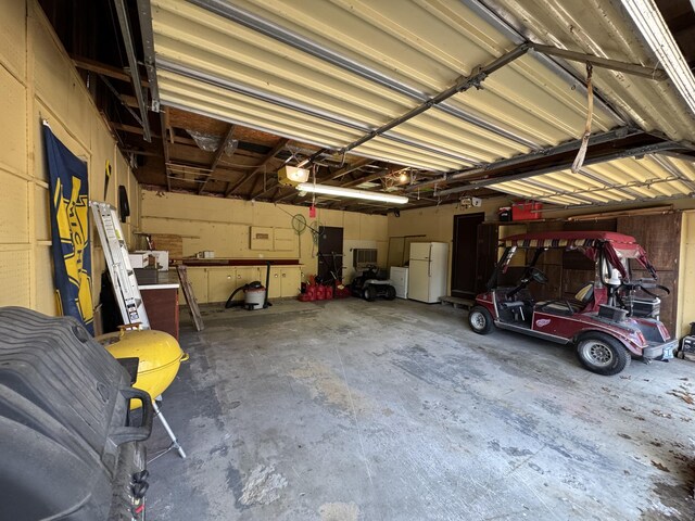 1570 E College Dr, Lewiston, MI 49756 - garage featuring freestanding refrigerator and a garage door opener
