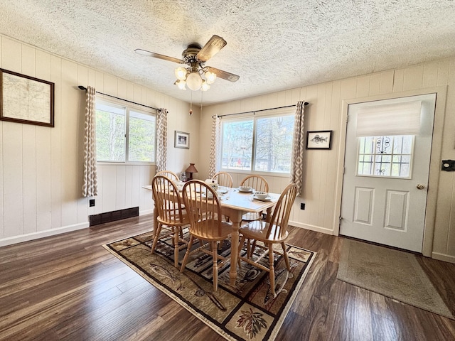 1570 E College Dr, Lewiston, MI 49756 - dining room with dark wood-style floors, a ceiling fan, a textured ceiling, and baseboards