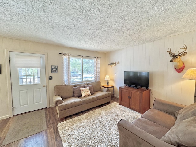 1570 E College Dr, Lewiston, MI 49756 - living area featuring wood finished floors, a textured ceiling, and baseboards