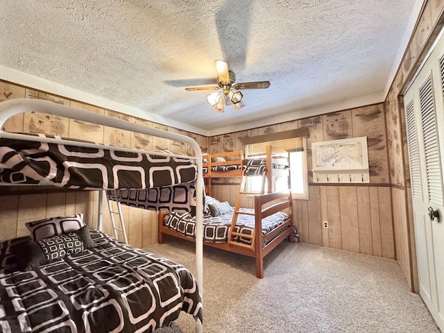 1570 E College Dr, Lewiston, MI 49756 - bedroom with wood walls, carpet floors, a textured ceiling, and a ceiling fan