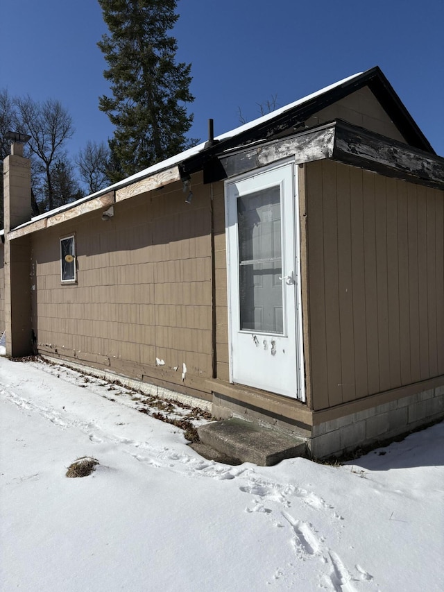 9419 W Airport Rd, Saint Helen, MI 48656 - view of snow covered exterior with a chimney and entry steps