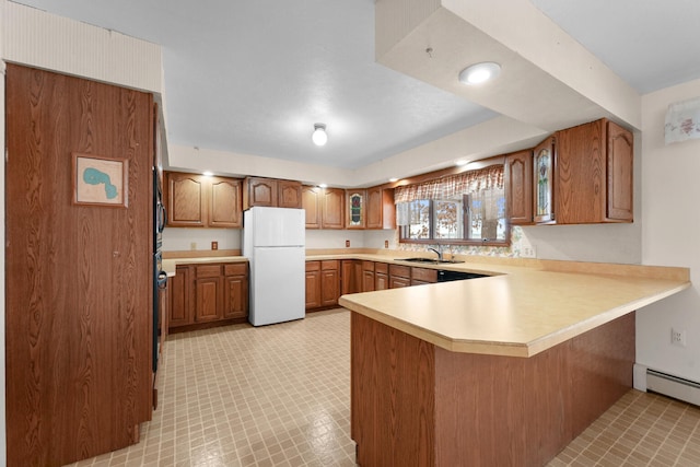 1384 W Higgins Lake Dr, Roscommon, MI 48653 - kitchen with freestanding refrigerator, a sink, a peninsula, and brown cabinets