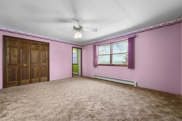 1384 W Higgins Lake Dr, Roscommon, MI 48653 - unfurnished bedroom featuring a baseboard radiator, carpet flooring, and a closet