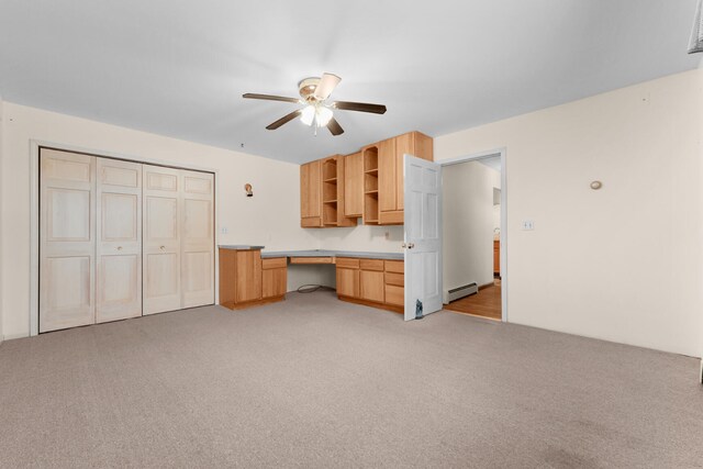 1384 W Higgins Lake Dr, Roscommon, MI 48653 - kitchen with open shelves, ceiling fan, light colored carpet, and a baseboard heating unit