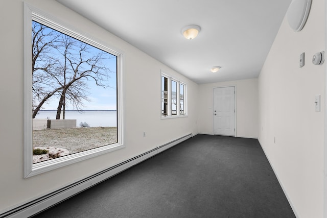 1384 W Higgins Lake Dr, Roscommon, MI 48653 - spare room featuring a baseboard radiator, a water view, and dark carpet