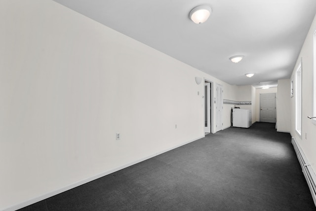 1384 W Higgins Lake Dr, Roscommon, MI 48653 - unfurnished living room featuring a baseboard radiator, dark carpet, and baseboards