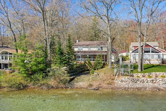 1384 W Higgins Lake Dr, Roscommon, MI 48653 - rear view of property featuring a chimney and a water view