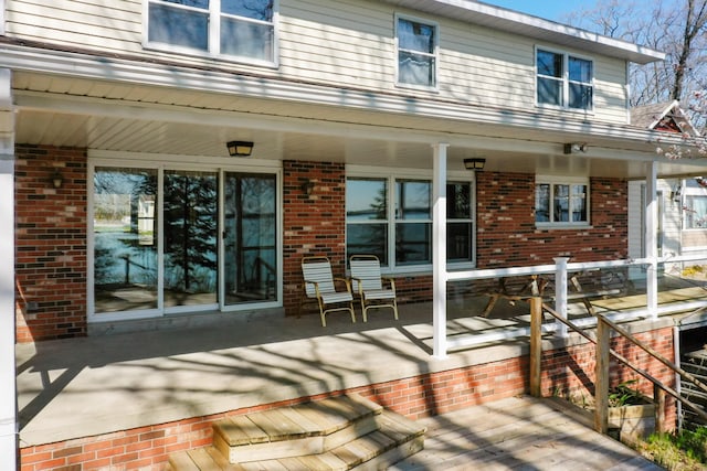 1384 W Higgins Lake Dr, Roscommon, MI 48653 - rear view of property featuring brick siding and covered porch
