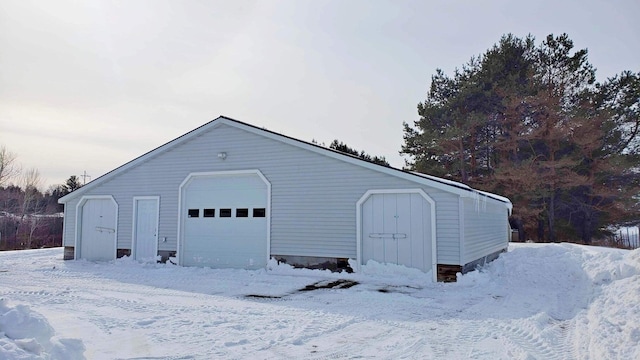 snow covered garage featuring a garage