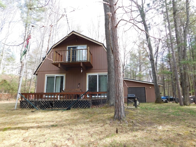 rear view of property with a yard, a wooden deck, and a balcony