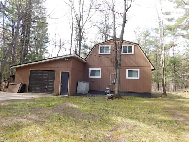 view of property exterior featuring a garage, a yard, and concrete driveway
