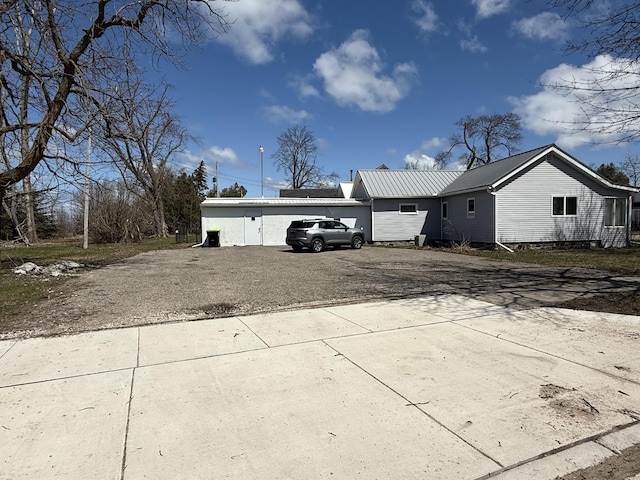 exterior space with metal roof, driveway, and an attached garage