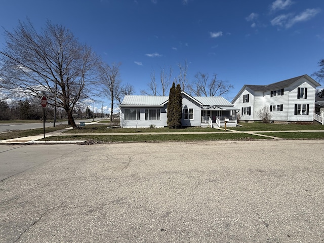 view of front of home featuring a front yard, metal roof, a porch, and crawl space