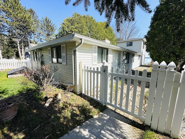 6382 W Higgins Lake Dr, Roscommon, MI 48653 - view of side of property with fence and a chimney
