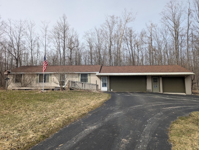 20776 Tennis Rd, Hillman, MI 49746 - view of front of house featuring an attached garage, a shingled roof, and a front yard