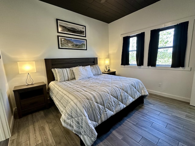 bedroom with baseboards, wooden ceiling, and wood finished floors