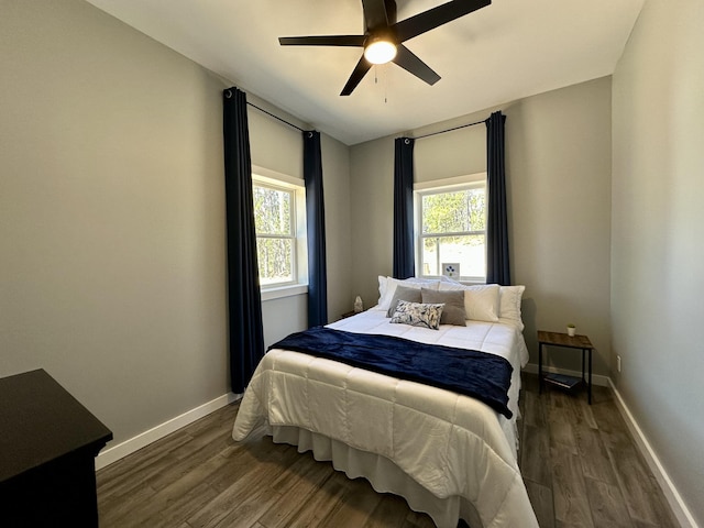 bedroom featuring baseboards, ceiling fan, and dark wood-type flooring