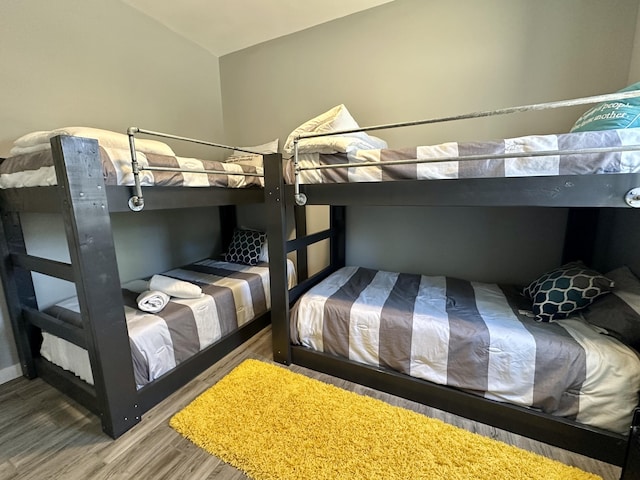 bedroom featuring wood finished floors and vaulted ceiling