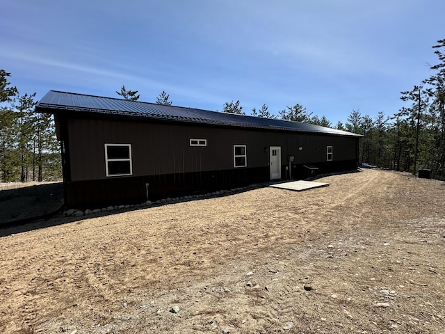 back of house featuring metal roof