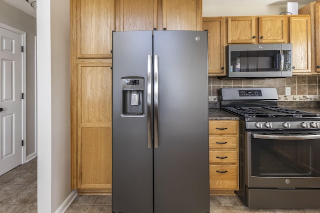 6150 Northpoint Dr, Saint Helen, MI 48656 - kitchen with appliances with stainless steel finishes, dark countertops, decorative backsplash, and tile patterned floors