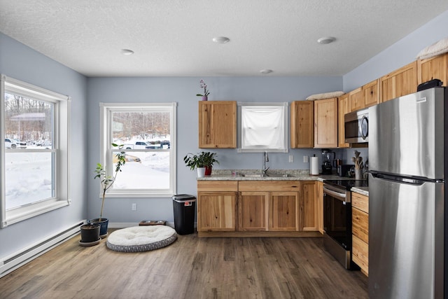 635 Gazelle St, Gaylord, MI 49735 - kitchen with a textured ceiling, dark wood-type flooring, stainless steel appliances, a baseboard radiator, and a sink