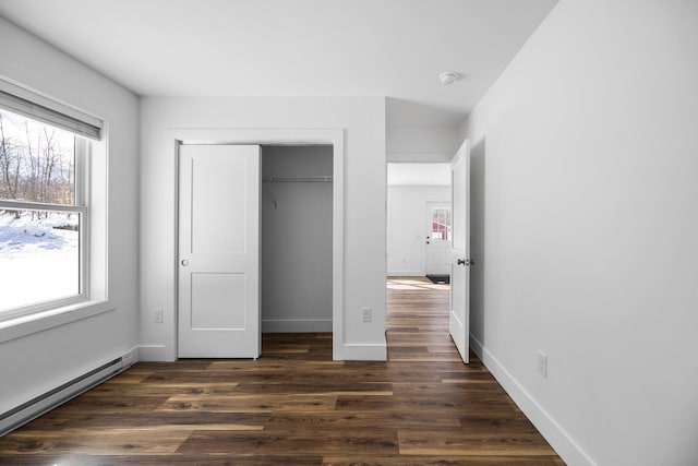 598 Gazelle St, Gaylord, MI 49735 - unfurnished bedroom featuring dark wood-type flooring, baseboards, multiple windows, and baseboard heating