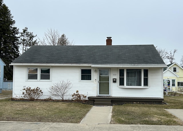 view of front of house featuring a chimney and a shingled roof