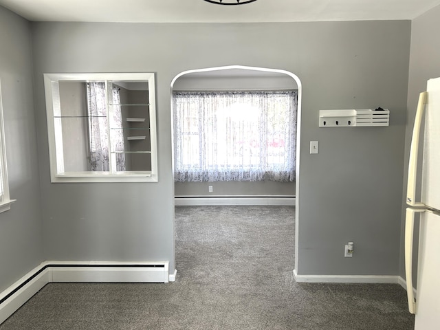unfurnished room featuring carpet, a baseboard heating unit, and baseboards