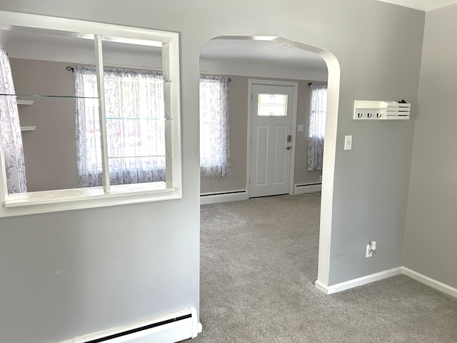 carpeted entryway featuring arched walkways, a baseboard radiator, and baseboards