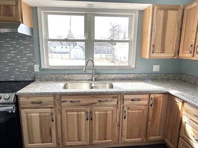 kitchen featuring wall chimney range hood, light stone countertops, electric range, and a sink