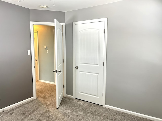 unfurnished bedroom featuring carpet and baseboards