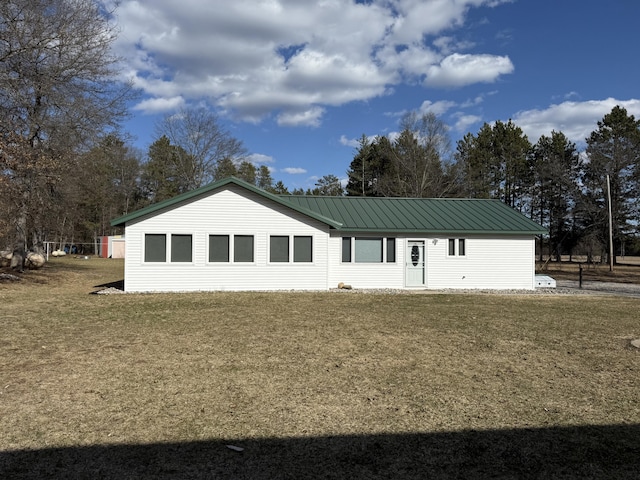 back of house with a yard and metal roof