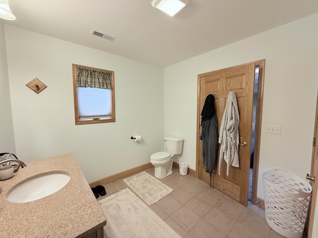 bathroom with toilet, baseboards, visible vents, and vanity