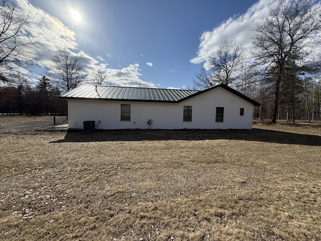 view of home's exterior with central AC and metal roof