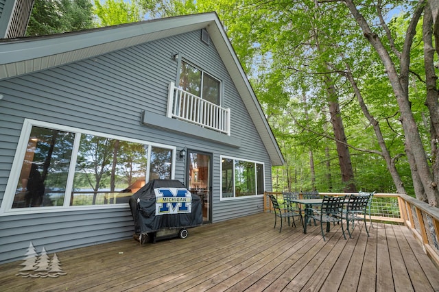 wooden terrace featuring a grill and outdoor dining area