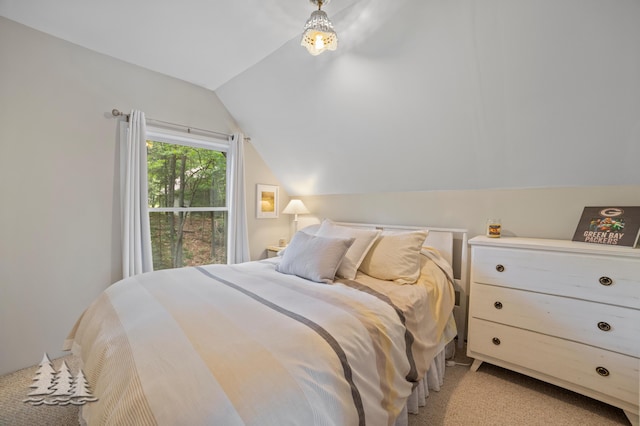 bedroom with light colored carpet and vaulted ceiling
